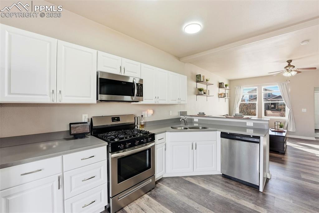 Image 10 of 41: Kitchen with stainless steel appliances, white cabinets, and a peninsula