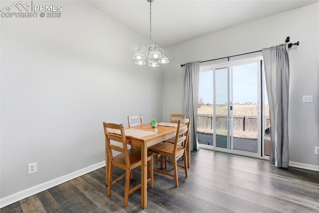 Image 11 of 41: Dining room with vaulted ceiling, dark wood finished floors, and hanging li