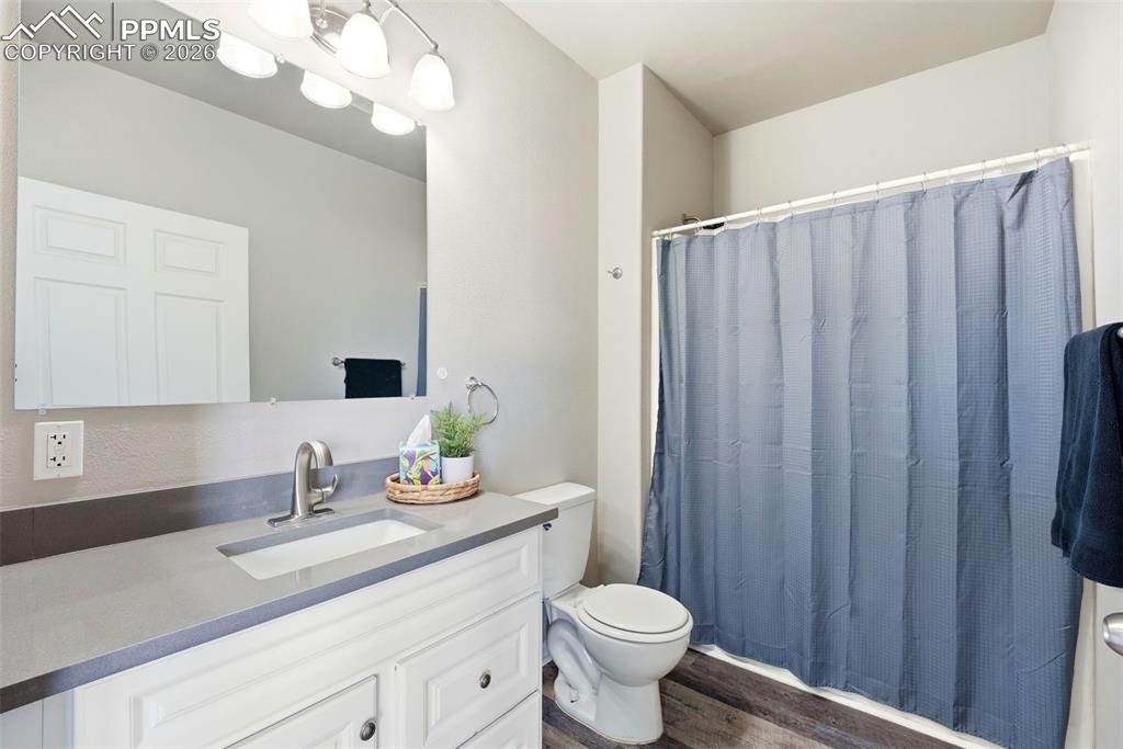 Image 21 of 41: Bathroom with vanity, a shower with shower curtain, and dark wood finished 