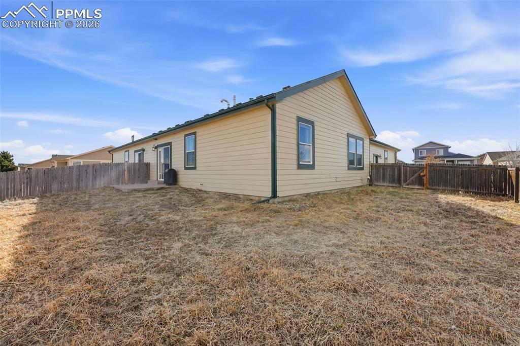 Image 29 of 41: Rear view of house featuring a fenced backyard and a patio