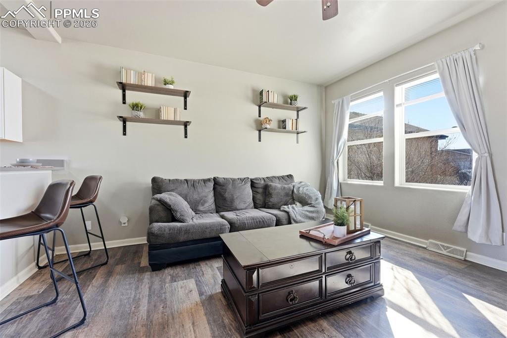 Image 7 of 41: Living area featuring ceiling fan and dark wood-style floors