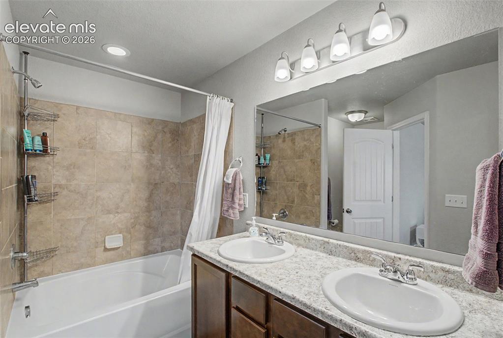 Image 23 of 34: Primary bathroom with double vanity and soaking garden tub/shower
