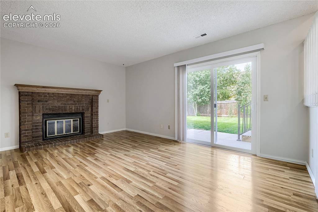 Image 11 of 30: Un-staged. Wood burning fireplace adds extra warmth to family room