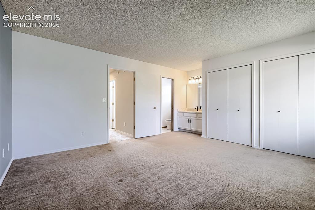Image 17 of 30: Primary bedroom showing 3/4 bath and double closet doors.