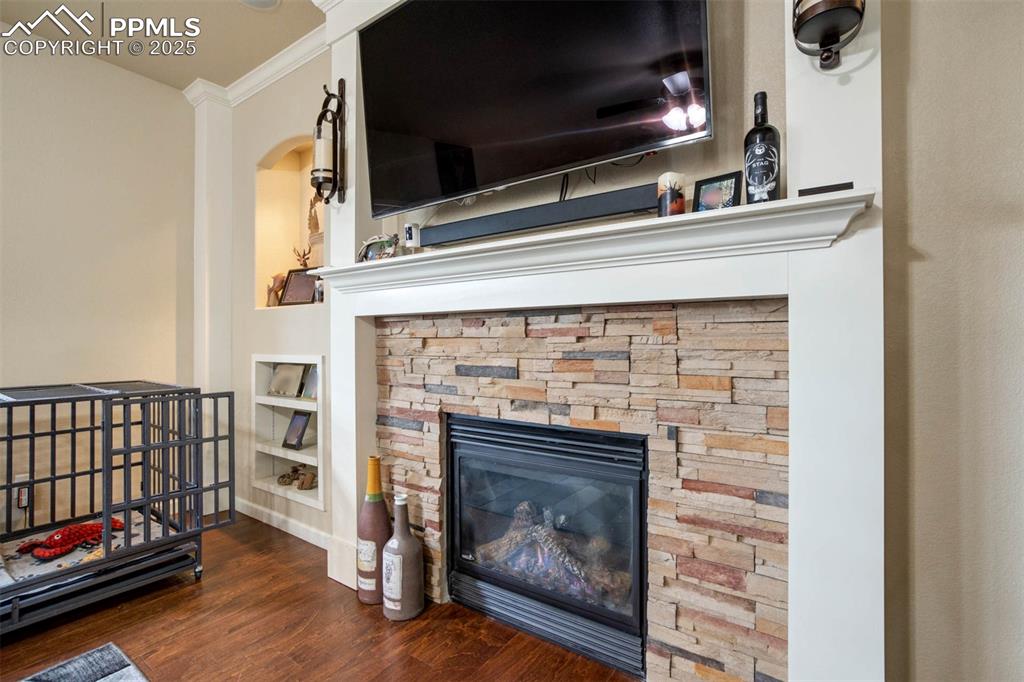 Image 10 of 49: Detailed view of ornamental molding, wood finished floors, a stone fireplac