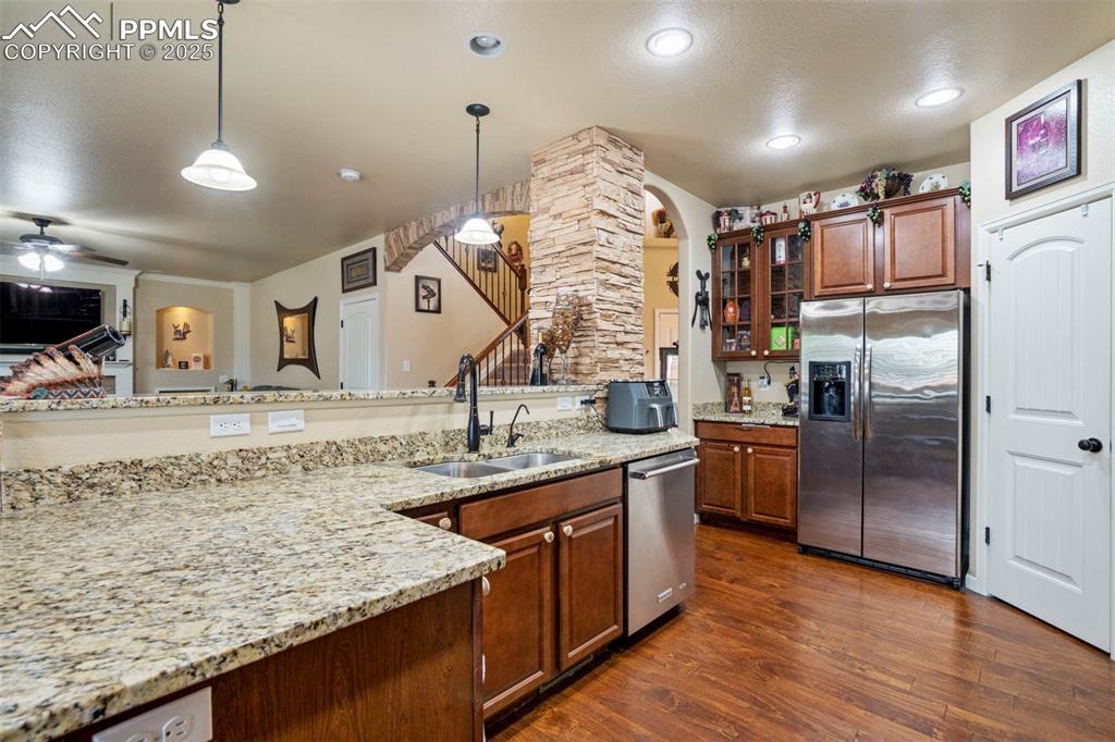 Image 14 of 49: Kitchen featuring stainless steel appliances, ceiling fan, glass insert cab