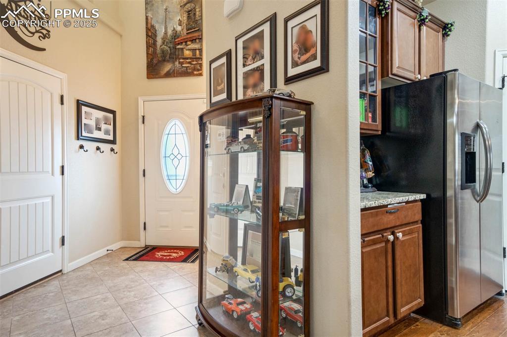 Image 16 of 49: Foyer entrance featuring light tile patterned floors and baseboards