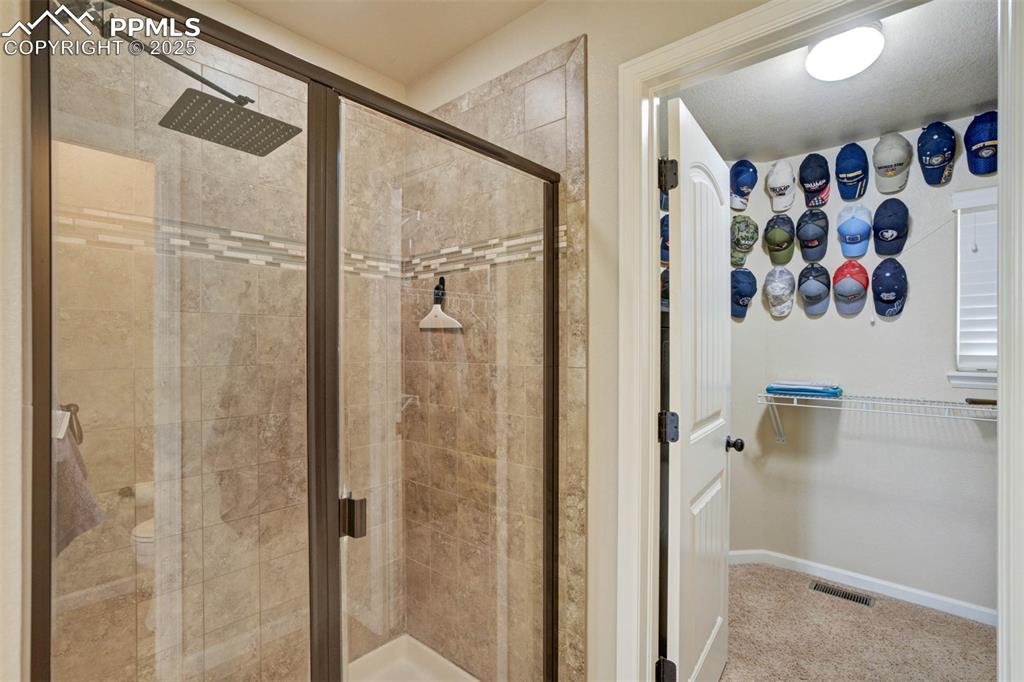 Image 24 of 49: Full bath with a stall shower and a spacious closet