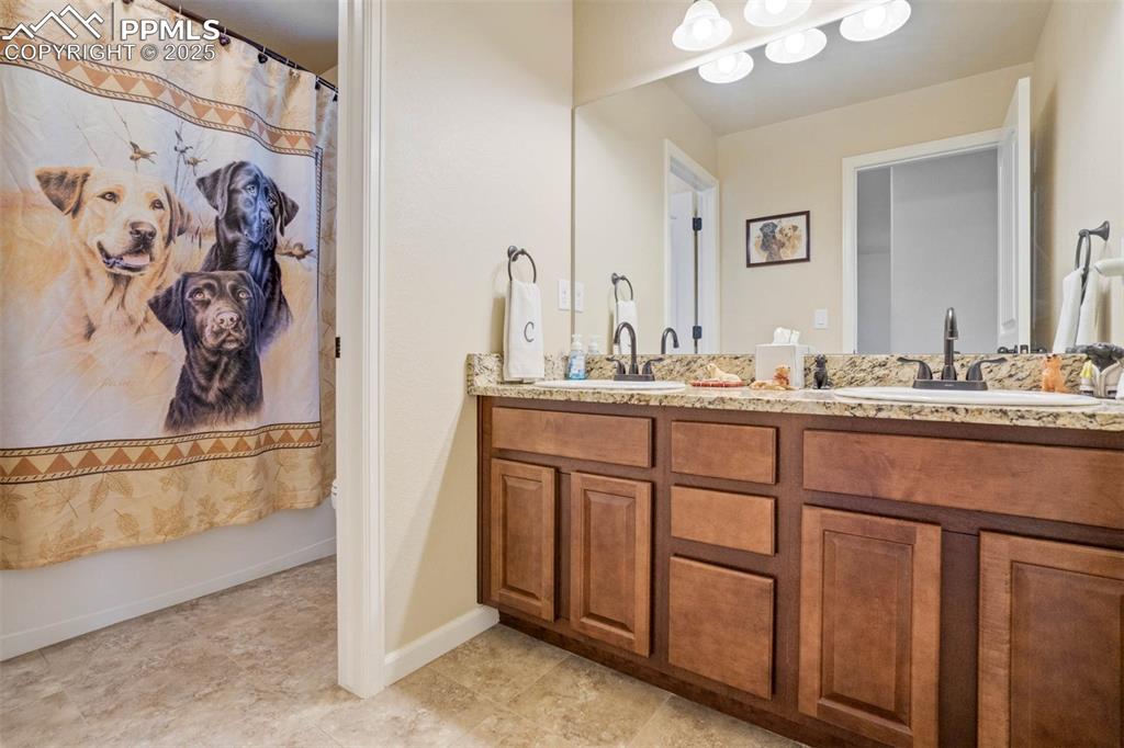 Image 34 of 49: Full bath with double vanity and a shower with shower curtain