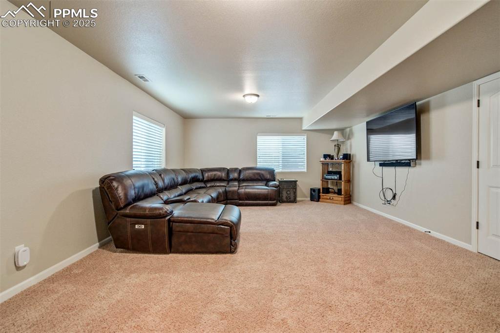 Image 37 of 49: Carpeted living area with baseboards