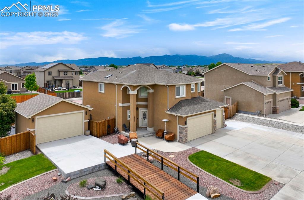 Image 5 of 49: View of front facade featuring a residential view, driveway, a mountain vie