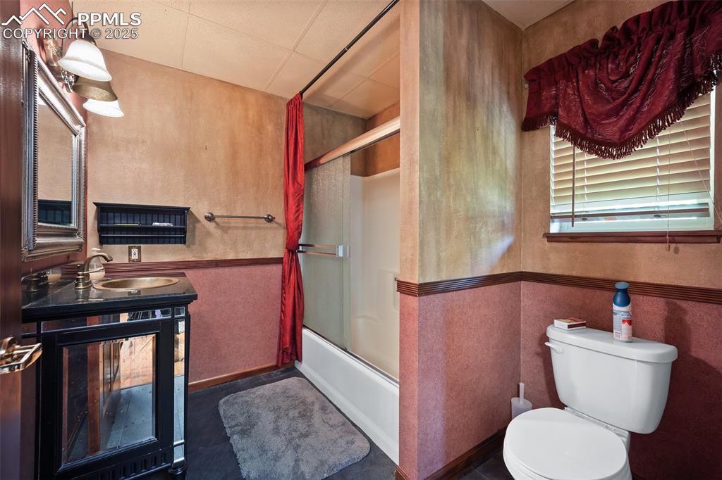Image 12 of 50: Full bath with toilet, bath / shower combo with glass door, and vanity - 57