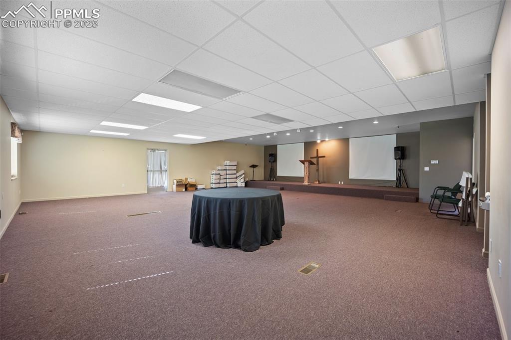 Image 15 of 50: Misc room with a drop ceiling, carpet floors, and baseboards - 5785 Buildin