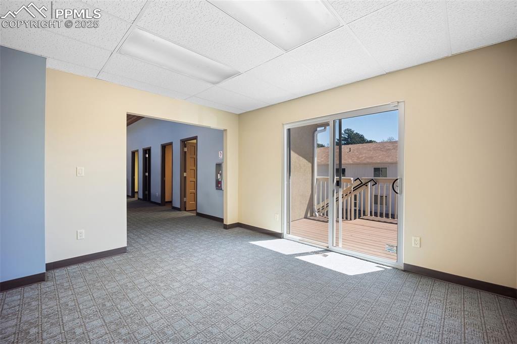 Image 22 of 50: Unfurnished room featuring a paneled ceiling, carpet flooring, and baseboar