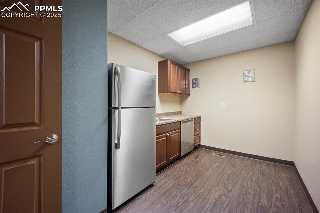 Image 26 of 50: Kitchen with appliances with stainless steel finishes, a paneled ceiling, d