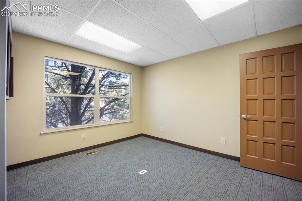 Image 29 of 50: Carpeted empty room featuring baseboards and a paneled ceiling-5775 Buildin