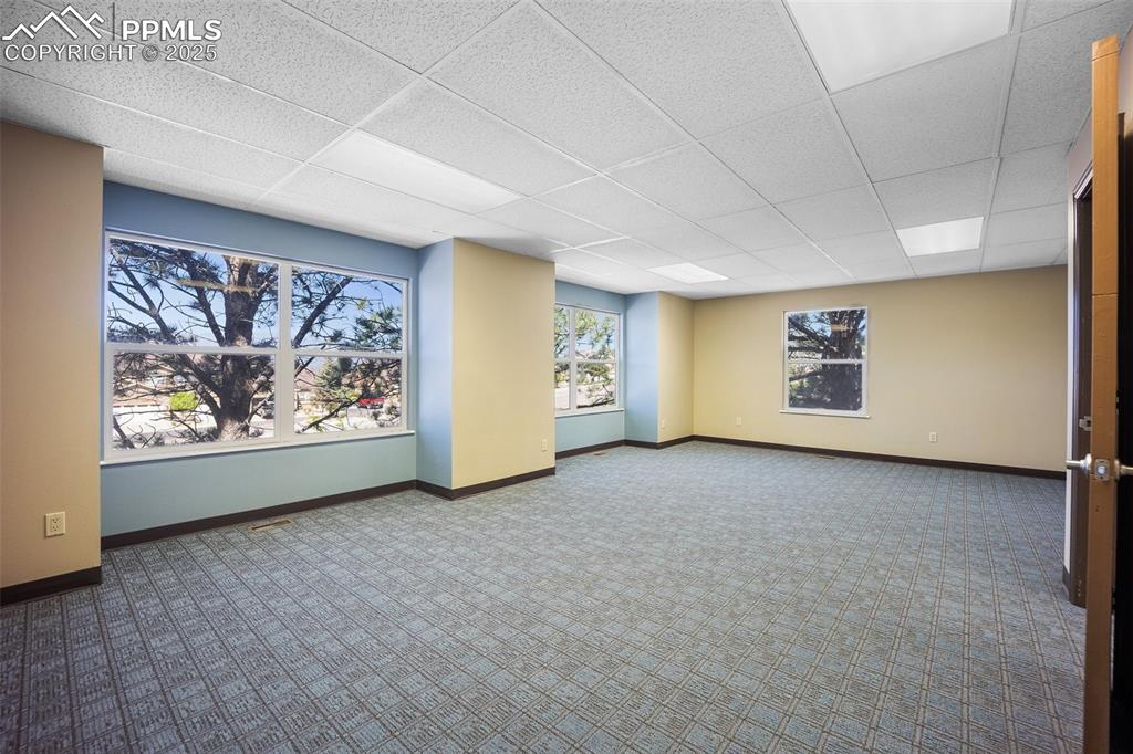 Image 31 of 50: Basement with carpet flooring, a drop ceiling, and baseboards-5775 Building