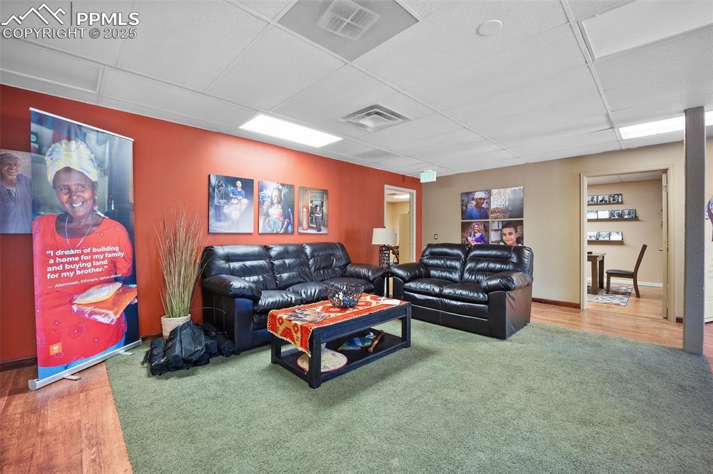 Image 41 of 50: Living area featuring a paneled ceiling and wood finished floors-5785 Build