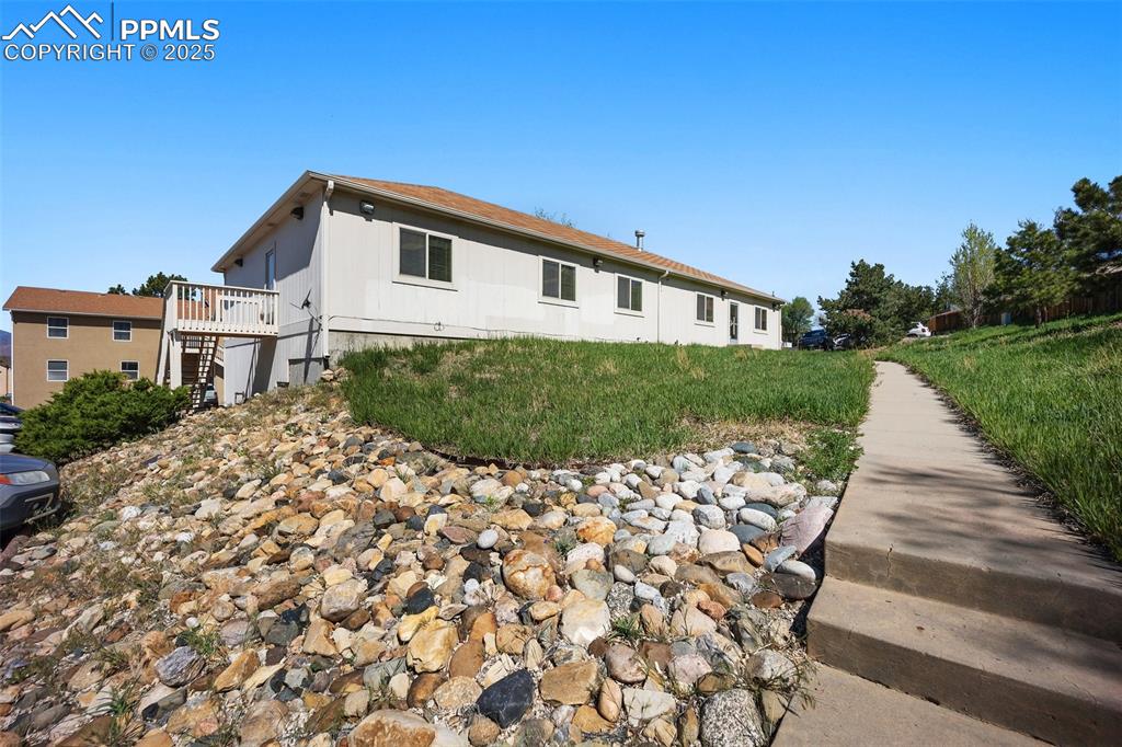 Image 48 of 50: View of side of home with stairs and a deck