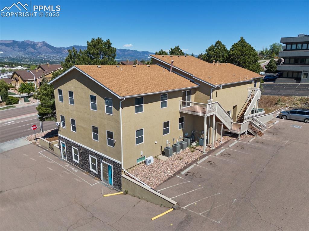 Image 6 of 50: Rear view of property with stairs, a shingled roof, and fence - 5785 Buildi