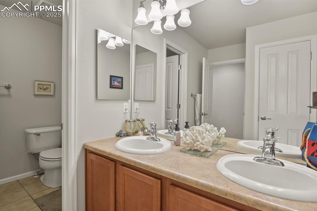 Image 17 of 27: Full bathroom featuring double vanity and light tile patterned floors