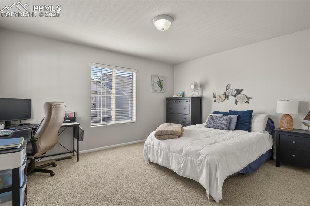 Image 24 of 27: Carpeted bedroom with baseboards and an office area