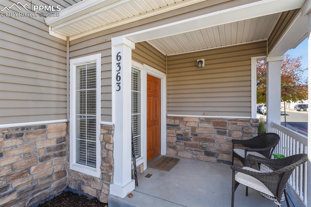 Image 3 of 27: Property entrance with a porch and stone siding