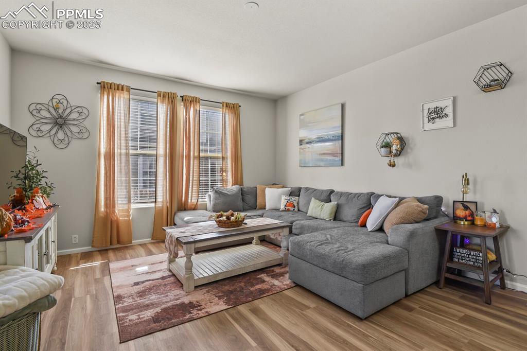 Image 4 of 27: Living area featuring wood finished floors and baseboards