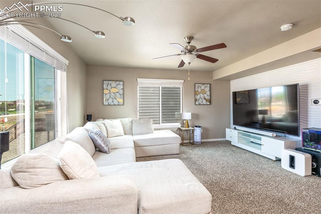 Image 5 of 40: Living room featuring ceiling fan, carpet flooring, and baseboards