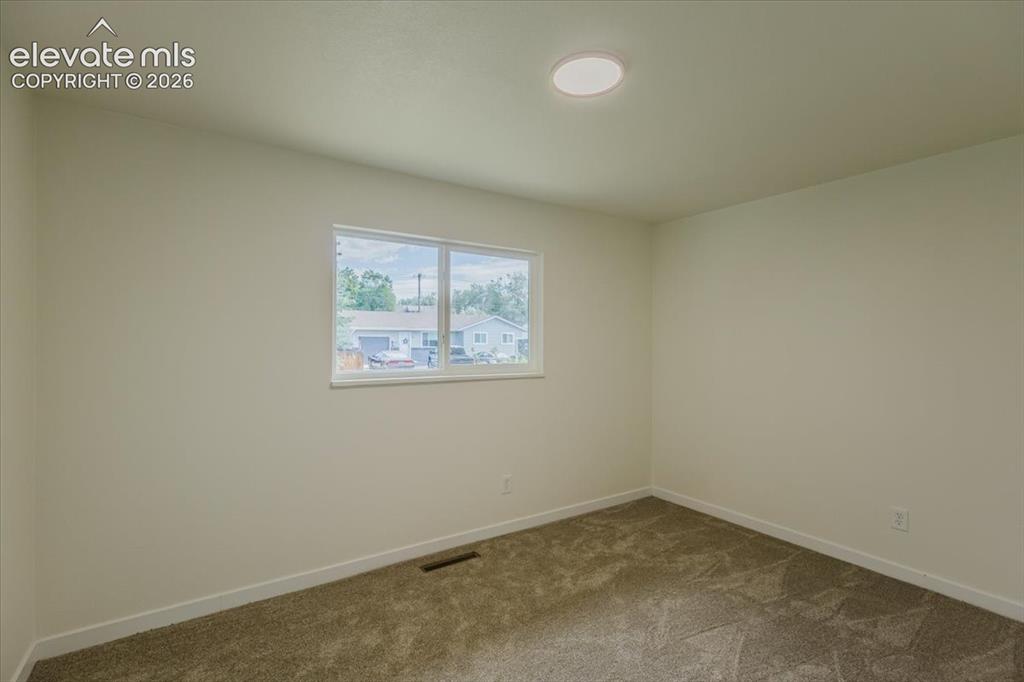 Image 10 of 27: Bedroom featuring plush carpeting, a single window, white baseboards, and a