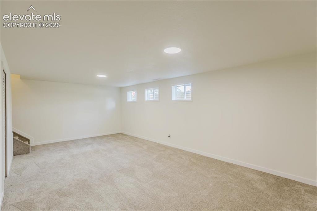 Image 16 of 27: Spacious room featuring neutral carpet flooring, recessed lighting, and whi