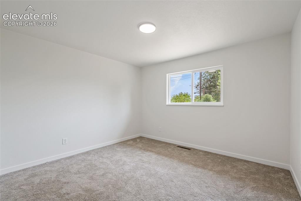 Image 16 of 35: Room featuring light gray carpeting, white walls, a white trim baseboard, a