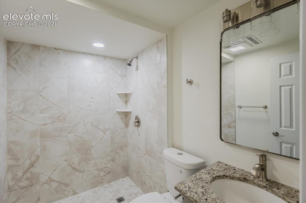 Image 18 of 27: Bathroom featuring a walk-in shower with large format marble-look tile, rec
