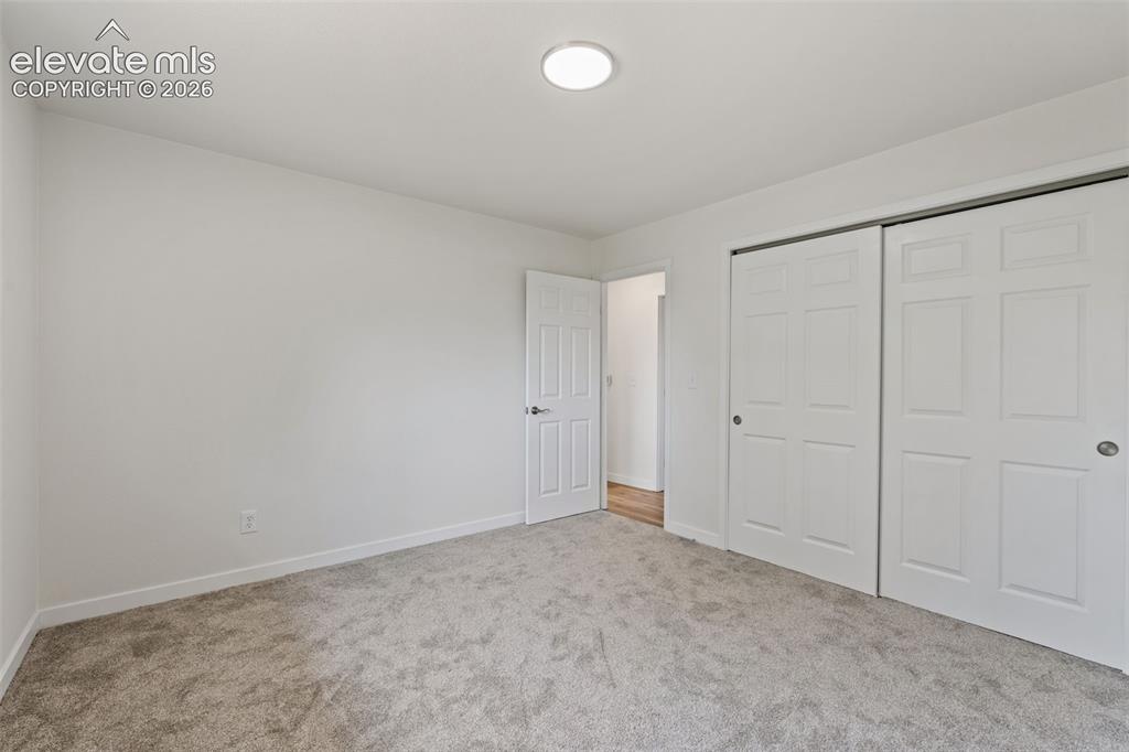 Image 18 of 35: Room featuring light gray carpeting, white painted walls, and a flush-mount