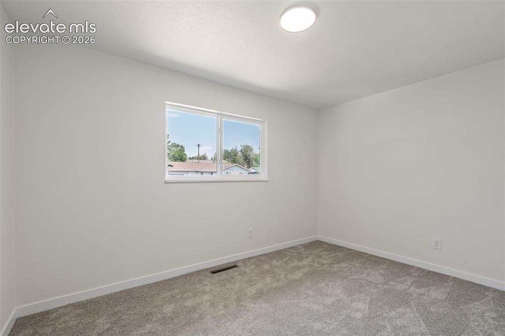 Image 20 of 35: Neutral tone wall paint with white trim, gray patterned carpeting, a double