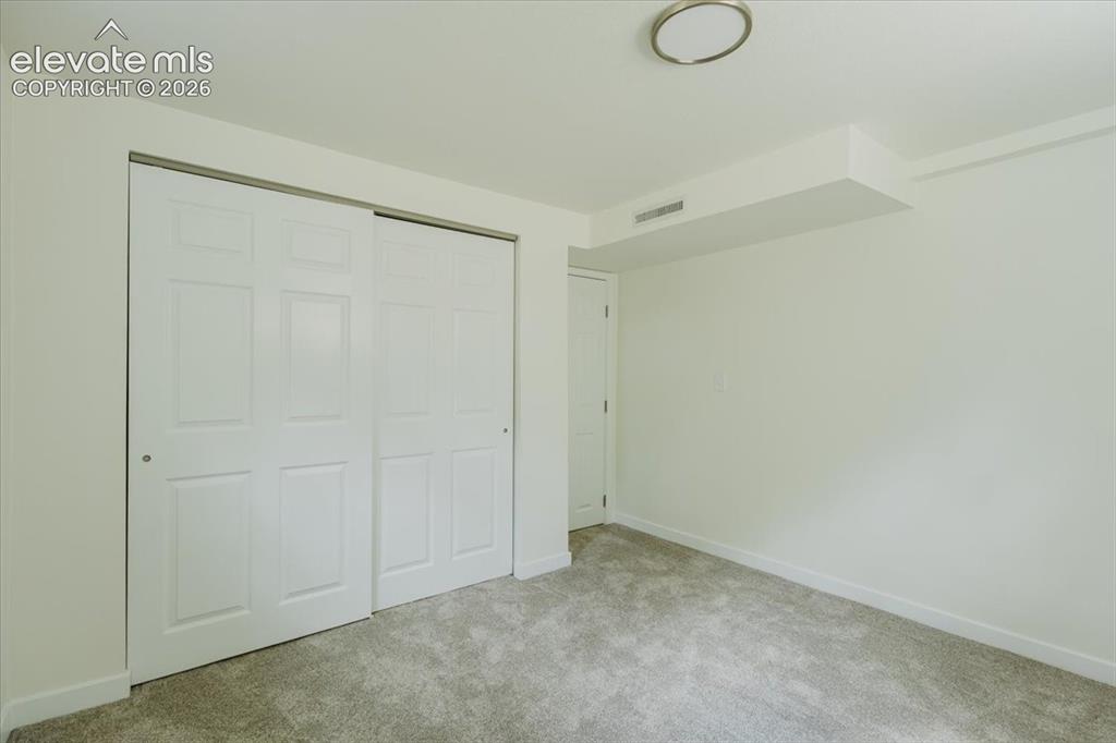 Image 21 of 27: Interior room featuring wall-to-wall carpeting, white walls, and a ceiling-