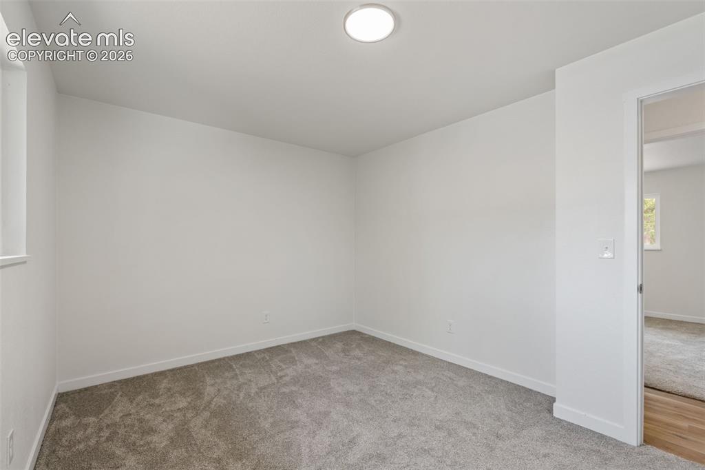 Image 21 of 35: Interior room featuring light gray carpet, white walls, and a ceiling-mount