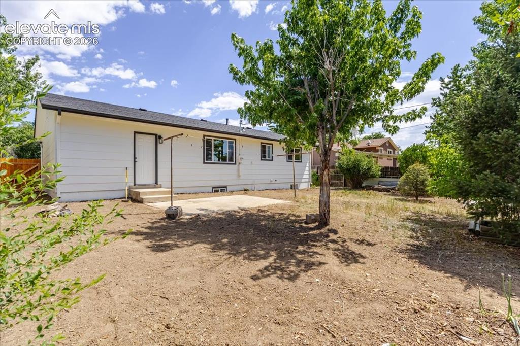 Image 27 of 27: Rear exterior with white siding, black-trimmed window, and concrete patio