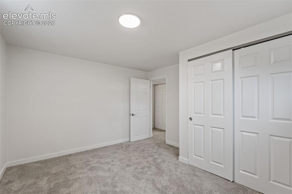 Image 27 of 35: Carpeted room featuring a ceiling-mounted light fixture, white walls, and w
