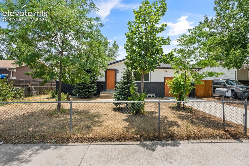 Image 3 of 35: Single-story residence featuring a white and dark gray exterior with an ora