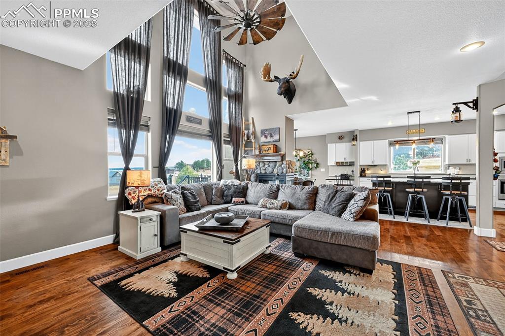 Image 13 of 39: Living area featuring dark wood-type flooring and a towering ceiling
