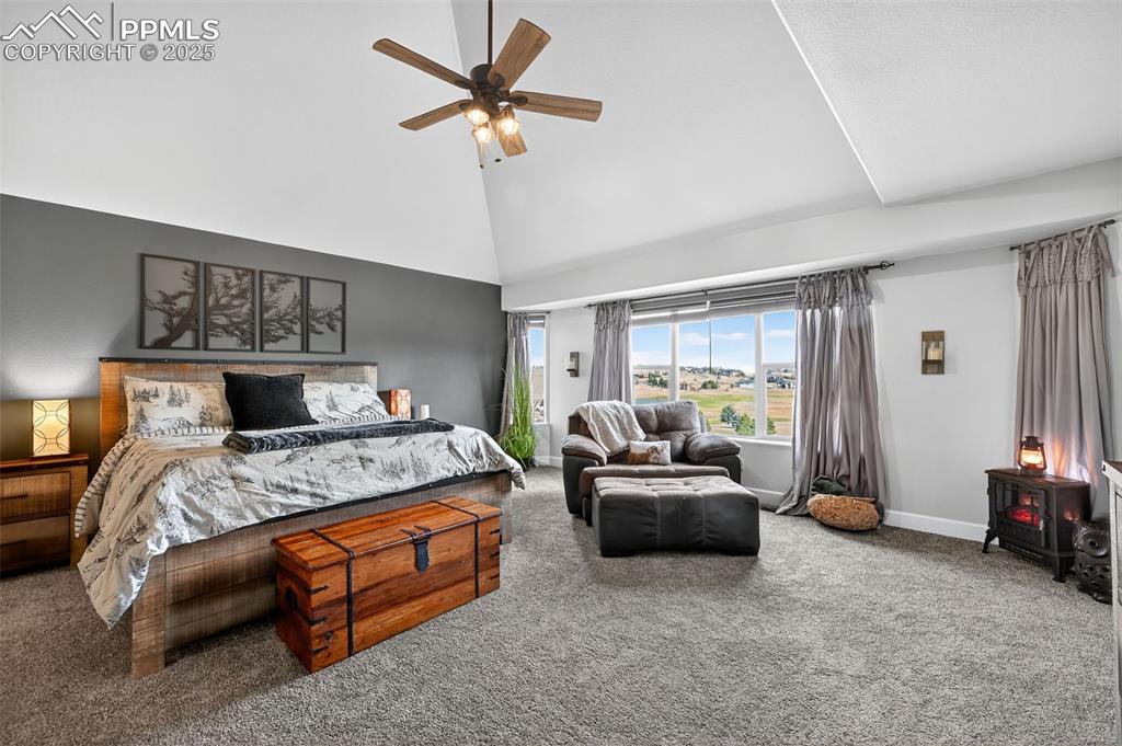 Image 25 of 39: Carpeted bedroom featuring ceiling fan and high vaulted ceiling