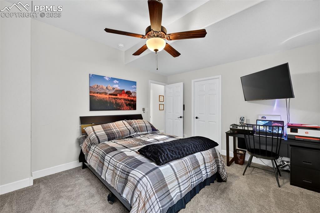 Image 30 of 39: Bedroom featuring light colored carpet, a ceiling fan, and a desk