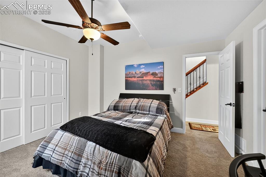 Image 31 of 39: Carpeted bedroom with a closet and a ceiling fan