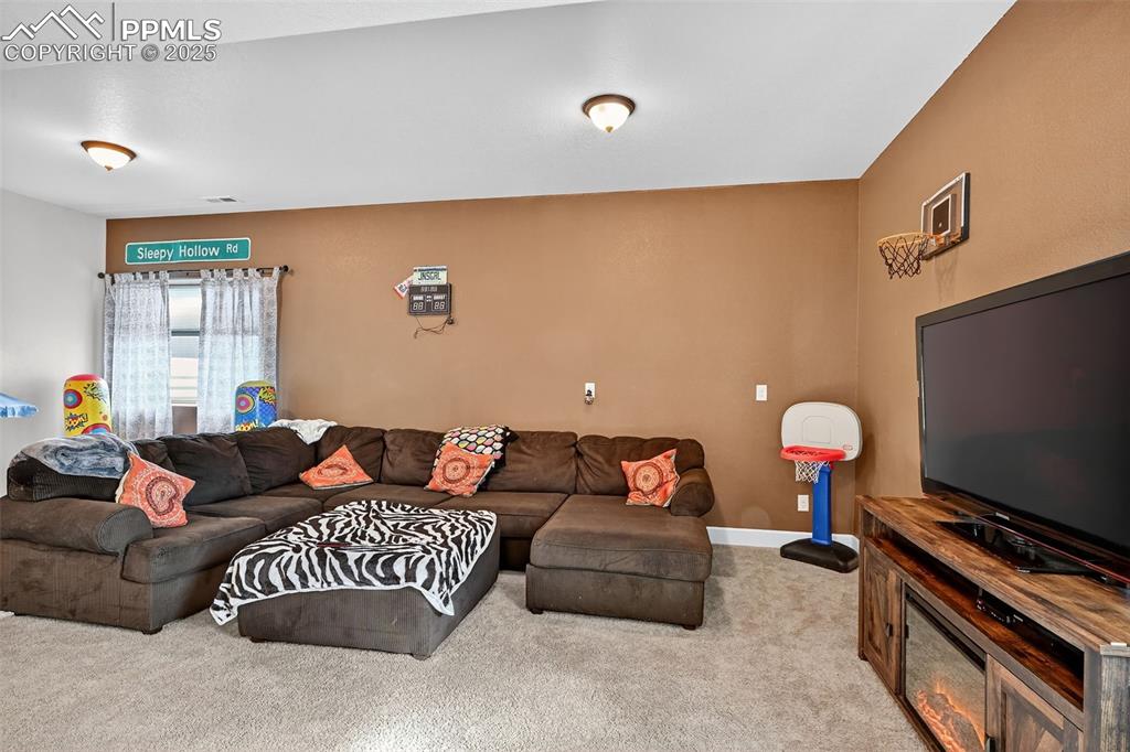 Image 34 of 39: Carpeted living area featuring baseboards