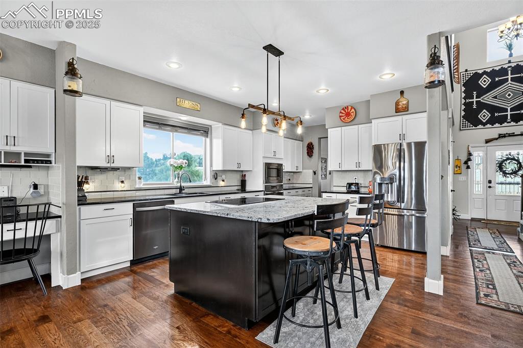 Image 6 of 39: Kitchen featuring tasteful backsplash, appliances with stainless steel fini