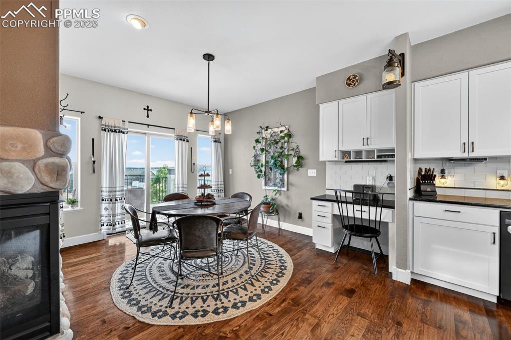 Image 9 of 39: Dining room featuring dark wood-style flooring, a fireplace, built in study