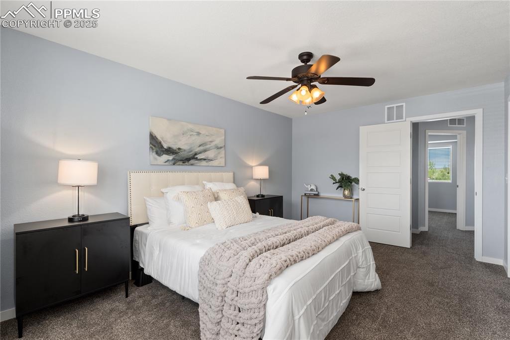 Image 17 of 33: Carpeted bedroom with a ceiling fan and baseboards