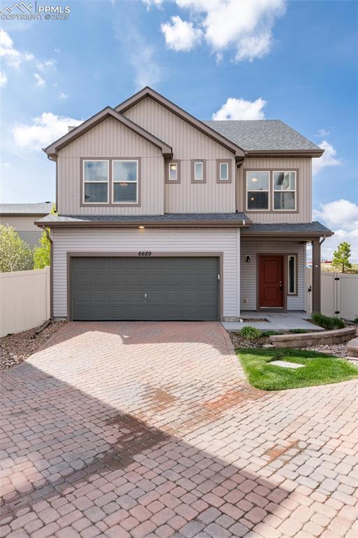 Image 2 of 33: View of front facade featuring a garage, decorative driveway, and a porch