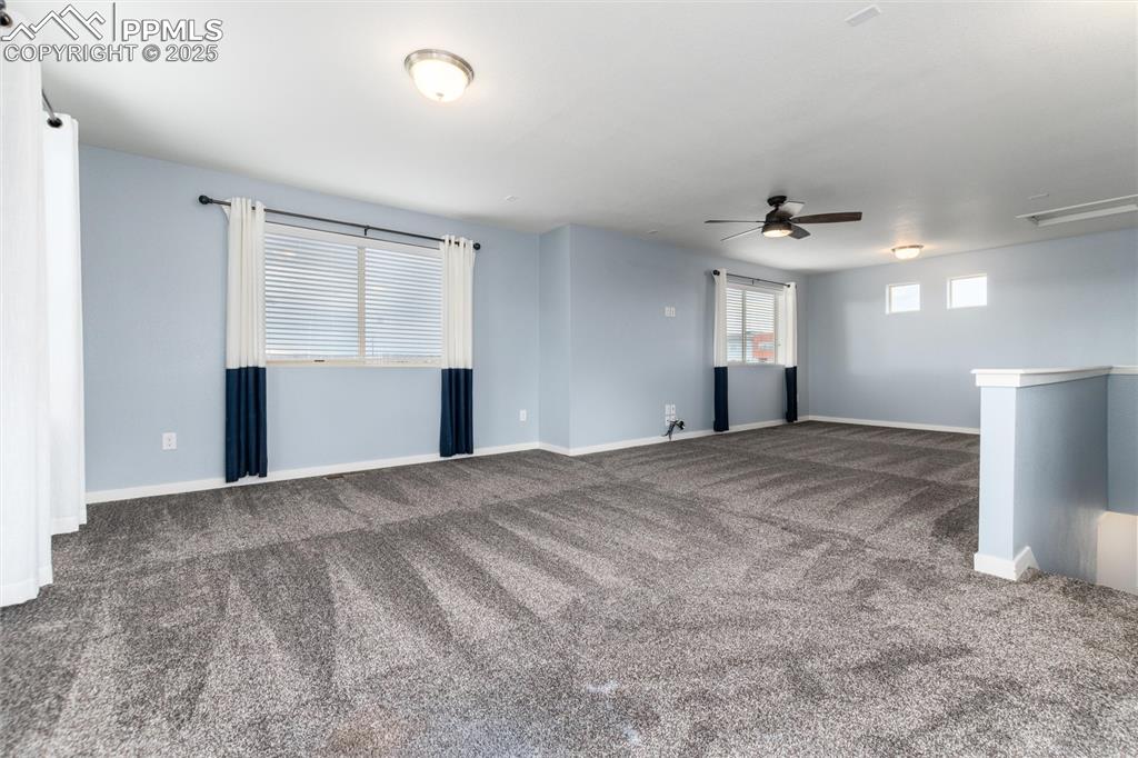 Image 25 of 33: Spare room with carpet floors, a ceiling fan, and baseboards